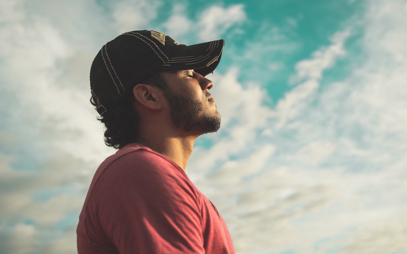 Man outside taking a deep breath