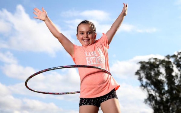Child hands in air with hula hoop