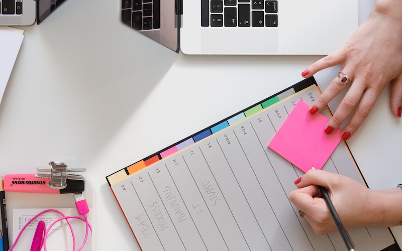 person writing on sticky notes